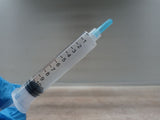 Liquid culture syringe held in a gloved hand